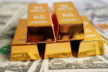 Gold bars on US dollar banknote money, finance trading investment business currency concept.