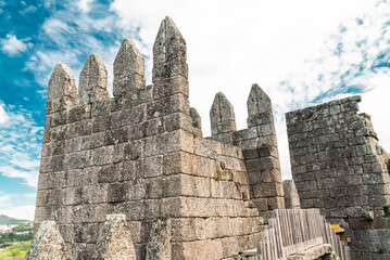 Wall Mural - Guimaraes, Portugal. April 14, 2022: Walls and structures of Guimarães castle with blue sky.