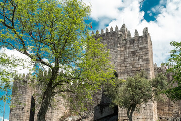 Wall Mural - Guimaraes, Portugal. April 14, 2022: Walls and structures of Guimarães castle with blue sky.