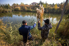 Men Fishing Near A Small Pond