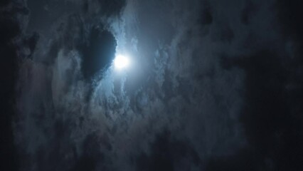 Wall Mural - black rays, light clouds, full moon and stars move across the night sky. timelapse. vertical video