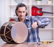 © Elnur - Young handsome repairman repairing drum