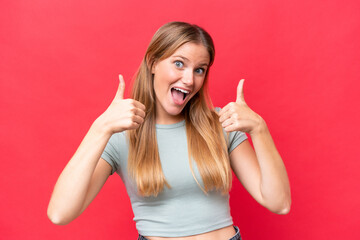 Wall Mural - Young beautiful woman isolated on red background giving a thumbs up gesture