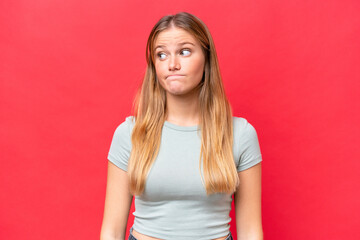 Canvas Print - Young beautiful woman isolated on red background making doubts gesture looking side