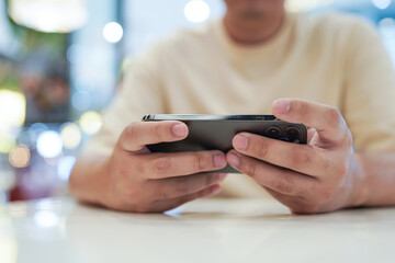 Man playing game on mobile phone. gamer boy playing video games holding Smartphone working mobile devices. cell telephone technology e-commerce concept