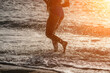 © panophotograph - Running woman on a summer beach. A woman jogging on the beach at sunrise, with the soft light of the morning sun illuminating the sand and sea, evoking a sense of renewal, energy and health.