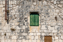Typical Old House With Weathered Closed Green Wooden Shutters And Stone Wall, Rogoznica Village, Dalmatia, Croatia