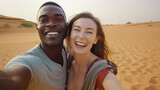Fototapeta Do akwarium - Photo of a multiracial couple capturing a moment on the sandy beach with a selfie