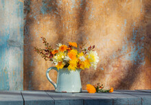 Chrysanthemum Flowers In Jug On Background Old Wall In Sunlight
