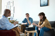 © Mediaphotos - Psychologist talking to couple at session while they sitting on sofa and listening to her