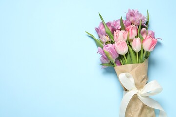 Wall Mural - Beautiful bouquet of colorful tulip flowers on light blue background, top view. Space for text