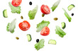 © New Africa - Lettuce leaves, olives, cut cucumber and tomatoes falling on white background
