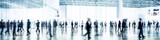 Fototapeta Londyn - blurred business people walking at a trade fair, conference or walking in a modern hall, motion speed blur,  wide panoramic banner