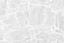 White Water With Ripples On The Surface. Defocus Blurred Transparent White Colored Clear Calm Water Surface Texture With Splashes And Bubbles. Water Waves With Shining Pattern Texture Background.