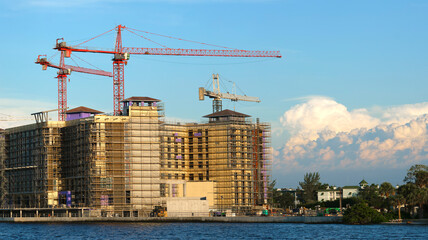 tower lifting cranes at high residential apartment buildings construction site. real estate developm