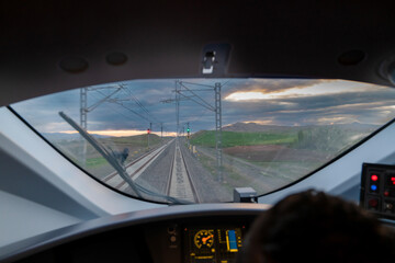 Motion blur view of railway from inside high speed train at evening and control panel of the locomotive