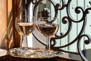 French cold rose dry wine from Provence in glasses served on window frame with wrought iron grille and wooden shutters, Provence, France