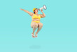Funny crazy overweight chubby woman in yellow swim suit, sun hat, flip flops with fat folds on belly jumps high up in air on blue background and makes loud beach holiday announcement through megaphone