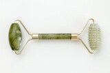 Fototapeta Konie - Facial jade massage roller made of green quartz stone on white background.