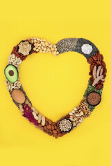 Wall Mural - Heart shape wreath with essential fatty acids healthy heart food containing lipids unsaturated good fats for low cholesterol levels with nuts, seeds, vegetables, dairy, legumes and grain. On yellow.