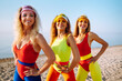 © maxbelchenko - Happy woman in colorful swimsuits are dancing in the morning at the beach. Сoncept of sports, fitness, aerobics. Active sport.
