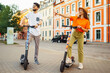 © maxbelchenko - Young couple having fun driving electric scooter through the city. Active life. Ecological transportation concept.