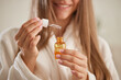 © st.kolesnikov - a young girl in a white coat applies vitamins to her hair at home, the concept of hair care