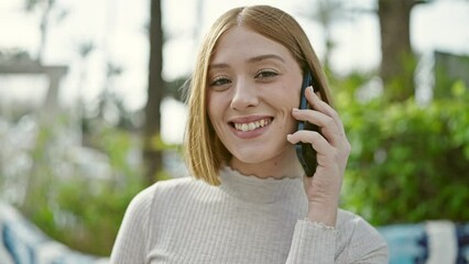 Wall Mural - Young blonde woman smiling confident talking on smartphone at park