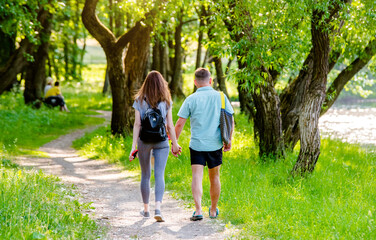 Wall Mural - A guy and a girl walk along the path in the city Park
