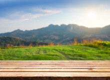 Wooden Table Top On Blur Mountain And Grass Field. Fresh And Relax Concept. For Montage Product Display Or Design Key Visual Layout. View Of Copy Space.