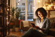 © Sasint - Beautiful mixed race woman browsing internet on cellphone in home living room. Happy hispanic sitting alone on floor in lounge and using technology to network. Laughing while scrolling on social media