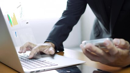Businessman working with laptop computer, showing chart and graph icons on virtual hologram digital screen interface. Big data analytics, BI business intelligence, investment and financial concept.