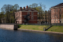 View Of A Brick Building, Formerly The Commandant's House, On The Island Of New Holland On The Banks Of The Moika River On A Sunny Day, St. Petersburg, Russia