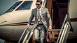 © PaulShlykov - Smiling businessman with private plane on background. Business jet exterior.