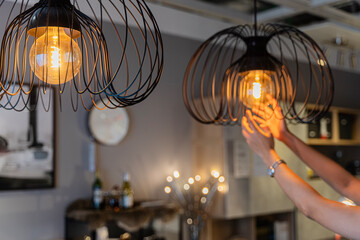 home maintenance concept modern interior, selective focus on light bulbs. woman changing light bulb 
