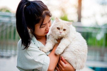 Woman holding cat playing at home with love for cats The smile glints in his bond with his fluffy pet cat. The relationship of people and cats, cat owners, domestic cats, fat cats