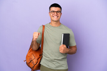 Handsome student man over isolated background celebrating a victory in winner position