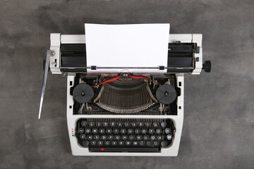 Fototapete - vintage typewriter on the table with blank paper on the grey desk - concept for writing, journalism, blogging