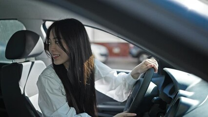 Sticker - Young chinese woman touching rearview sitting on car at street