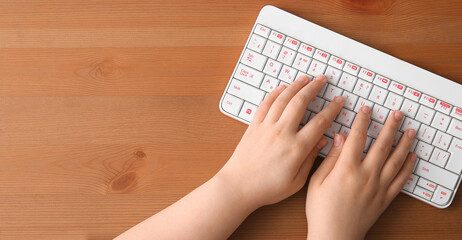 Hands of programmer and PC keyboard on wooden background with space for text, top view