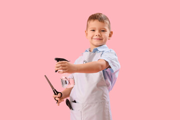 Funny little hairdresser with scissors and spray on pink background