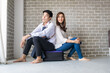 © themorningglory - Happy couple sitting onluggage in new room moving to a new home