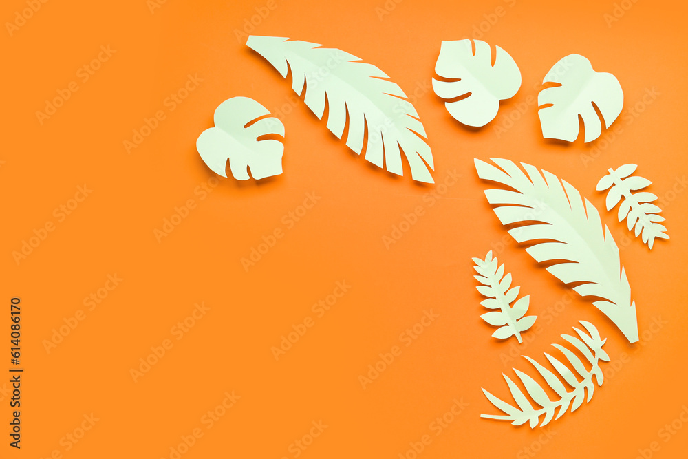 Light paper tropical leaves on orange background