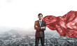 © adam121 - Concept of power and sucess with businessman superhero in big city