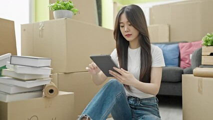 Poster - Young chinese woman smiling confident using touchpad at new home