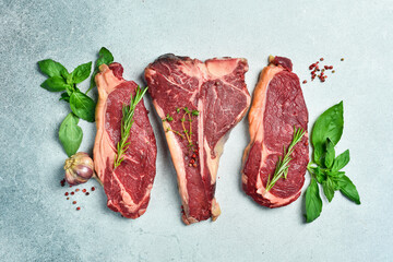 Wall Mural - Assortment of steaks and veal. Meat products. On a gray stone background. Top view.