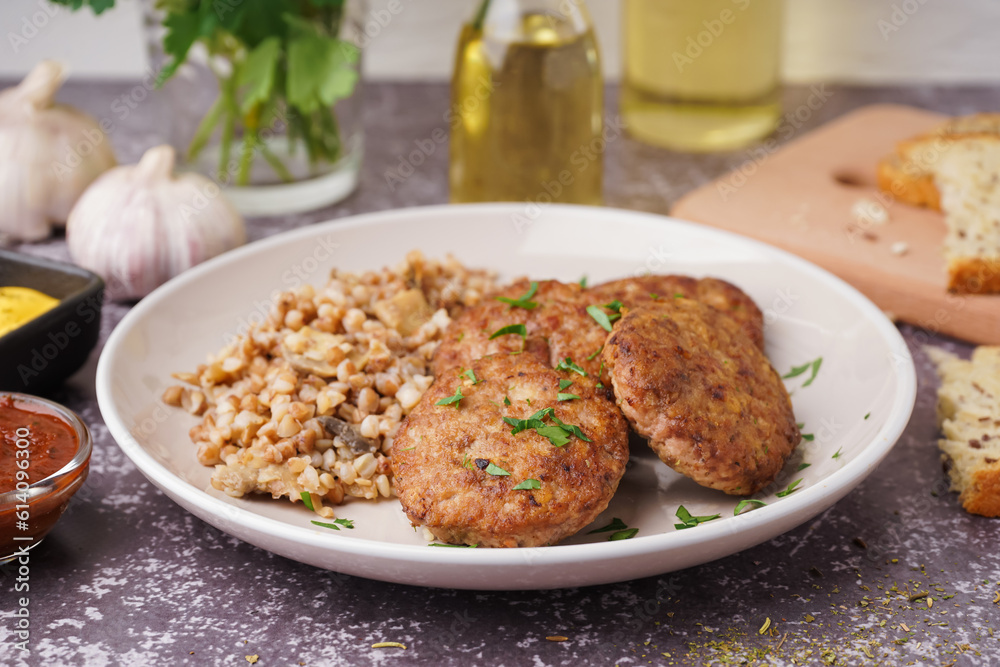 Cutlets with buckwheat, mushrooms and parsley on grey grunge table in kitchen