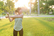 © Jirawatfoto - Female jogger. Fit young Asian woman with green sportswear stretching muscle in park before running and enjoying a healthy outdoor. Fitness runner girl in public park. Wellness being concept