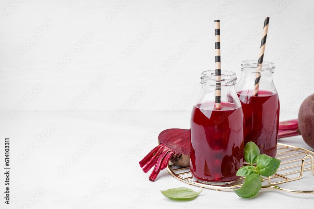 Bottles of fresh beetroot juice on white background