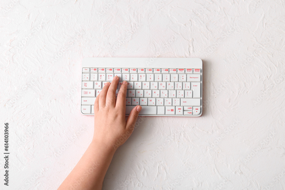 Female hand with modern computer keyboard on light background
